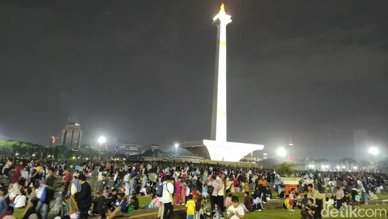 Hujan Tak Surutkan Warga, Yayat dari Berau Bertahan di Monas Sambut Tahun Baru Hujan Tak Surutkan Warga, Yayat dari Berau Bertahan di Monas Sambut Tahun Baru