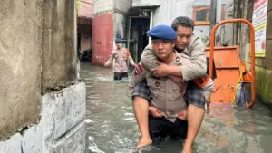 Brimob Polda Metro Gendong Warga Sakit Terjebak Banjir di Cengkareng, Jakarta Barat
